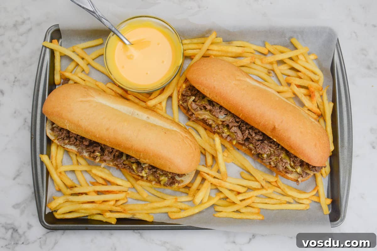 philly cheesesteak with fries on platter