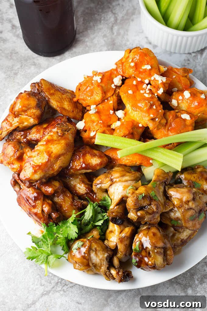 Three varieties of Chicken Wings on a white plate garnished with celery