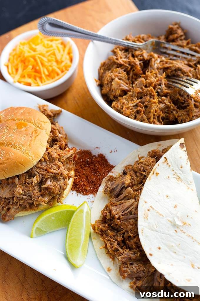 Pulled Pork on a hamburger bun next to pulled pork in flour tortilla on a rectangular white platter with bowl of pulled pork and knife in background