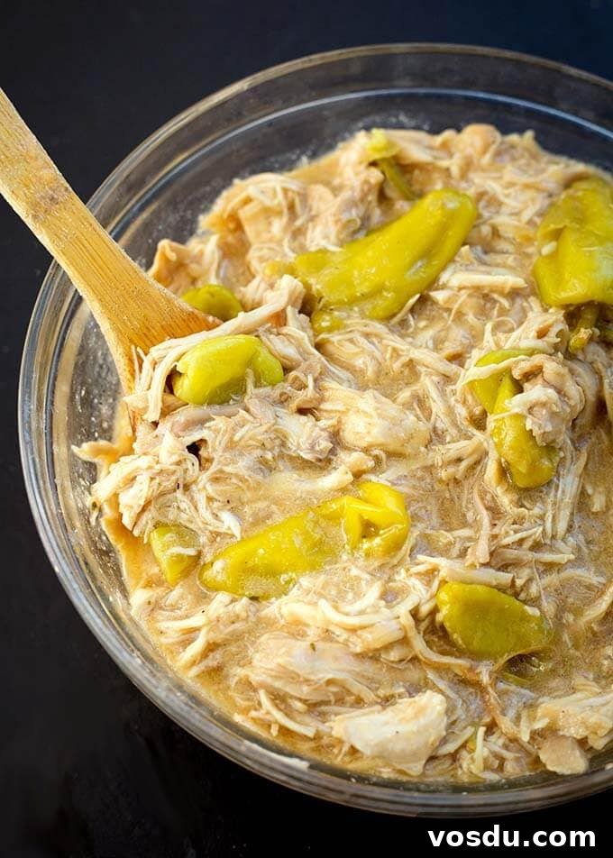 Mississippi Chicken in a glass bowl with wooden stirring spoon
