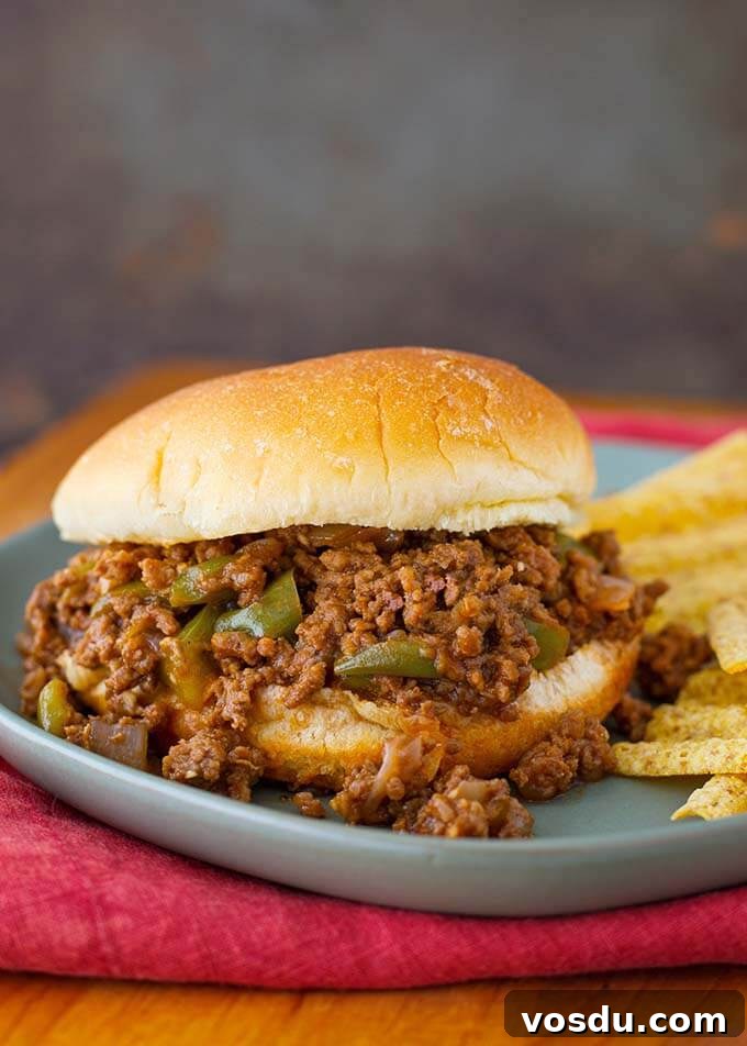 Sloppy Joe sandwich on blue plate with chips