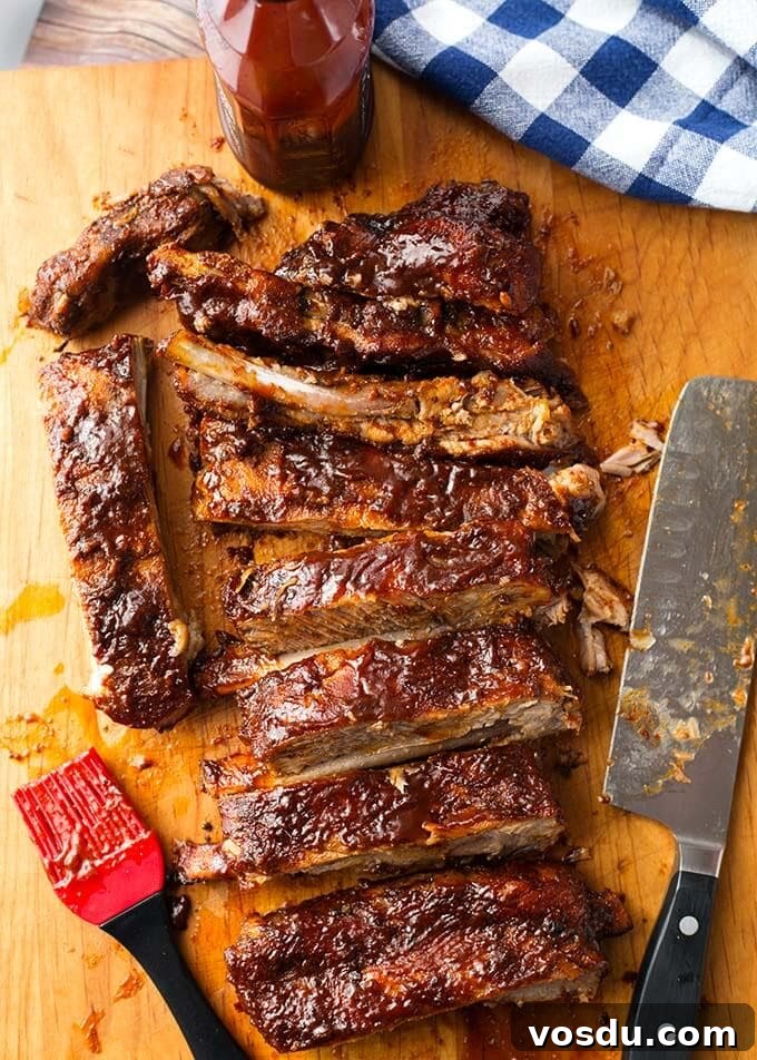 Cut Baby Back Ribs with meat cleaver and sauce brush on a wooden board