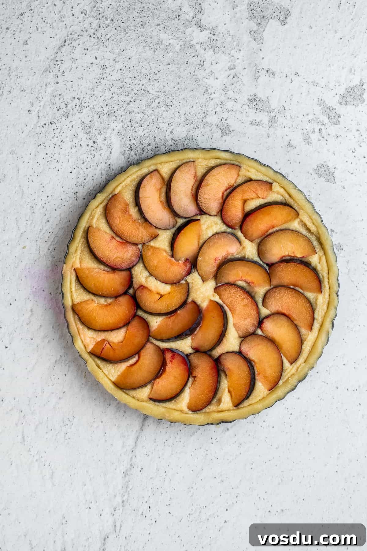 Plum slices on top of the frangipane filling.