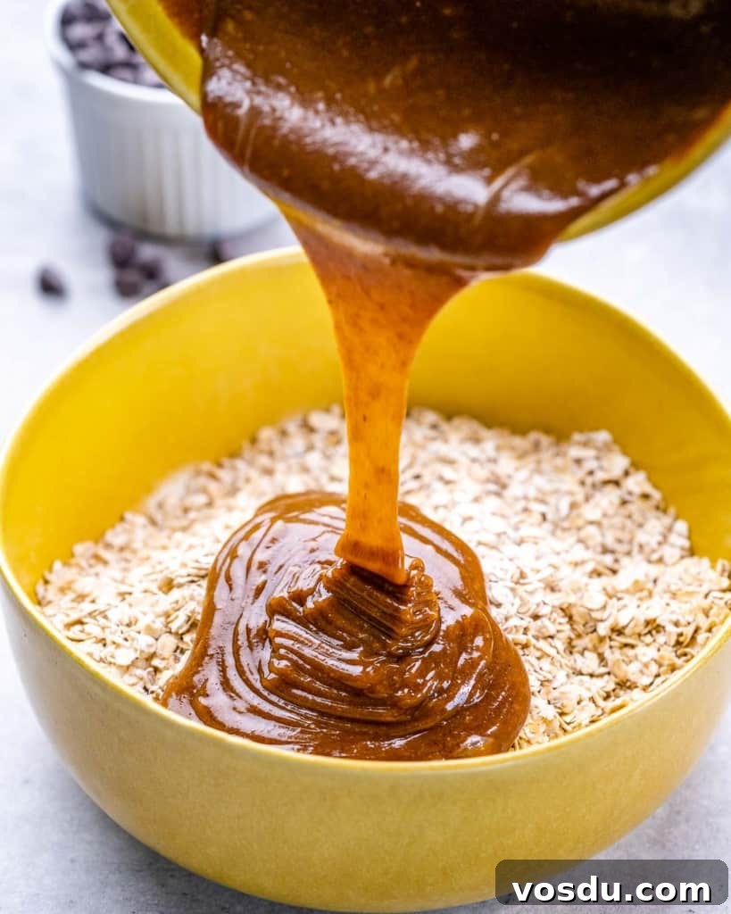 wet ingredients being poured over oatmeal