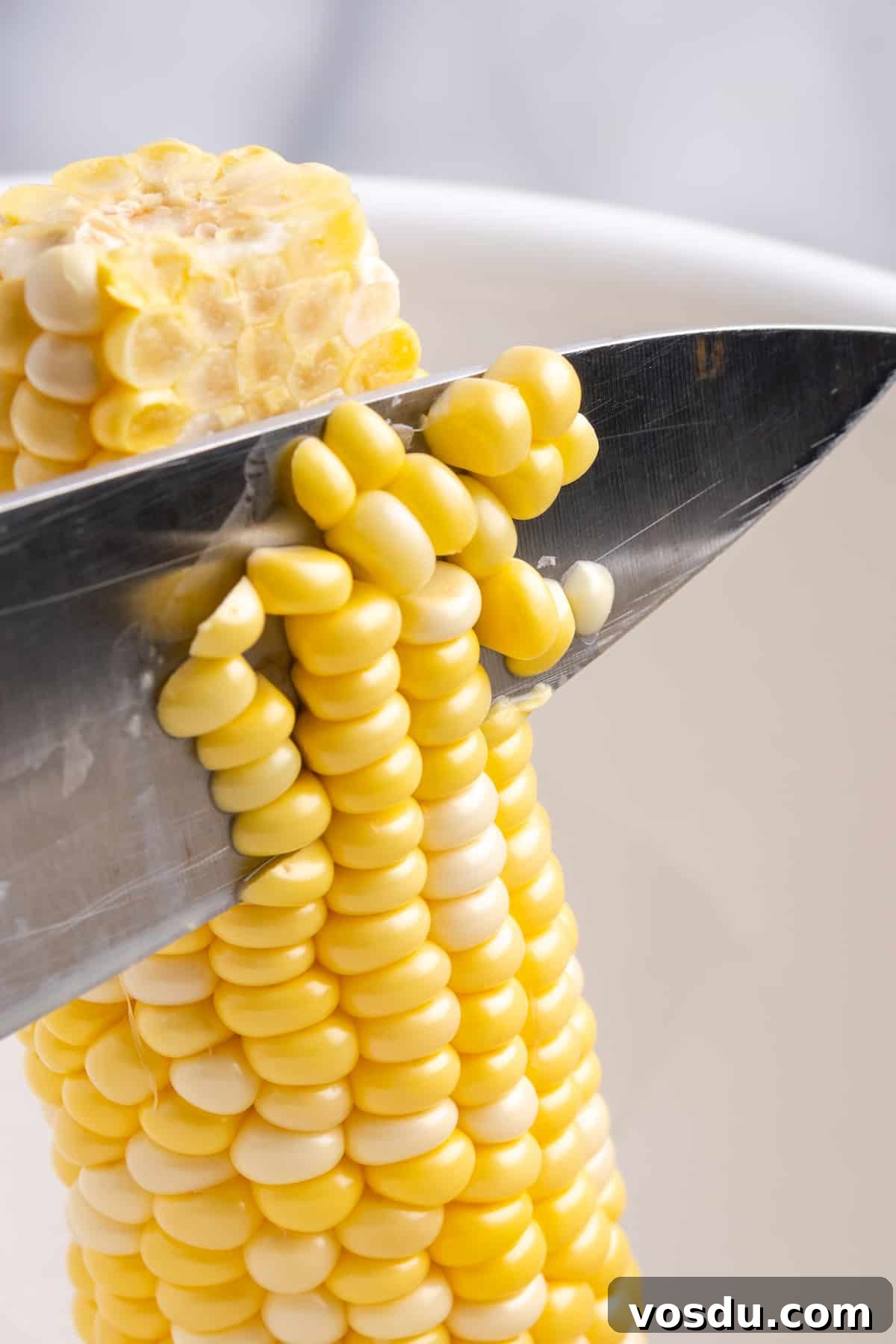 Knife cutting corn off cob