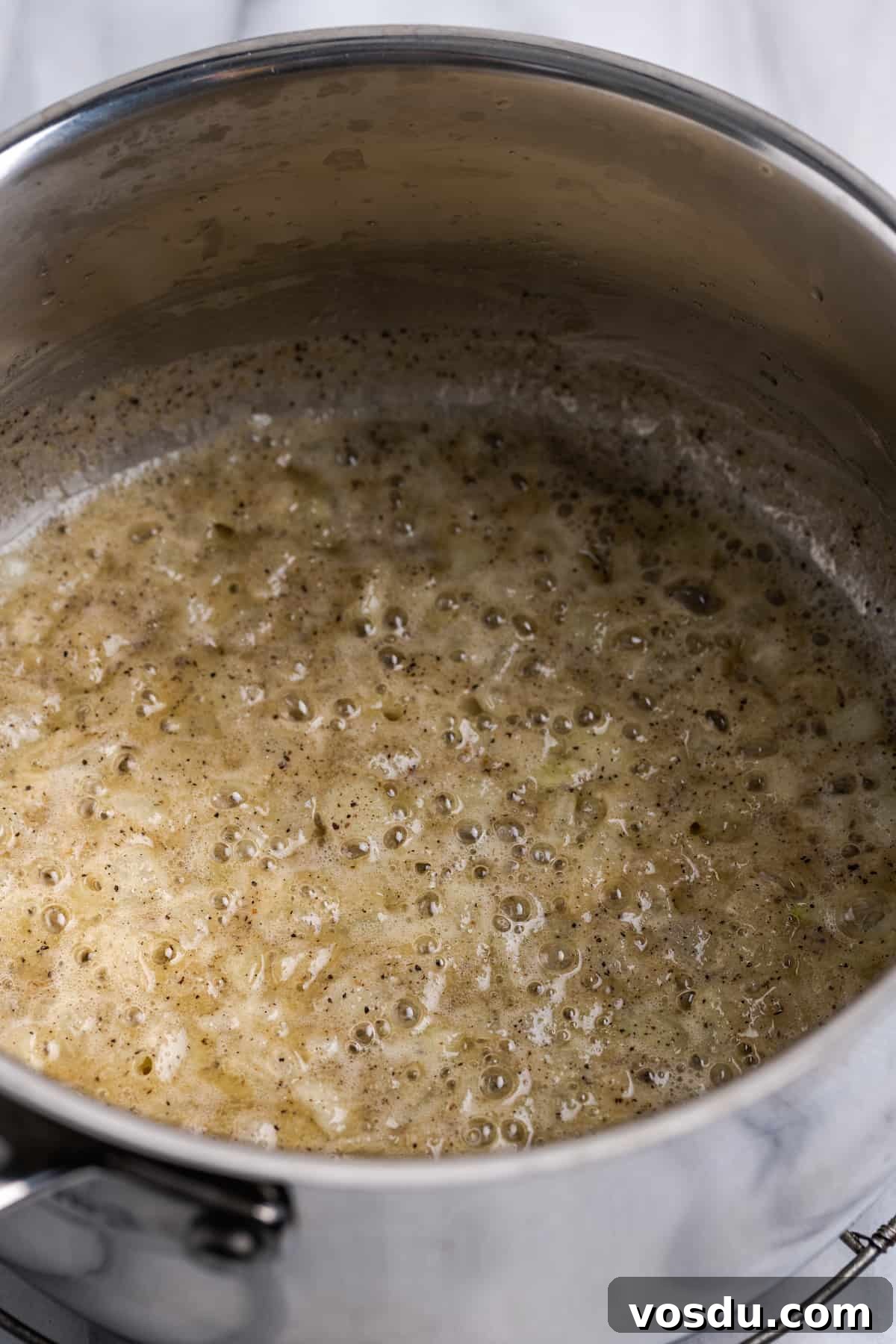 Vegan butter and onions cooking in pot